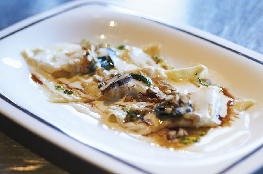 Homemade pumpkin casoncelli with taleggio cheese fondue and walnuts